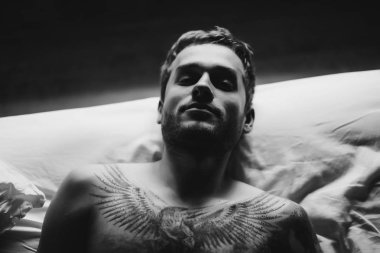 Yatakta dövmeli adam 