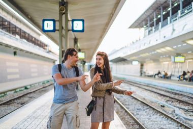 Genç mutlu çift tren istasyonunda dans portresi