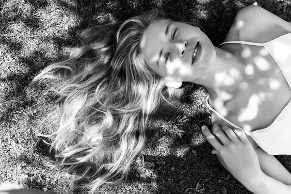 cute blonde woman on grass outdoor at summer, black and white