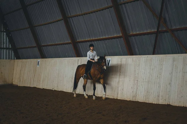 Chica en traje a caballo en la arena — Foto de Stock