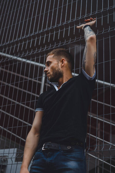 Человек позирует рядом с фехтованием
