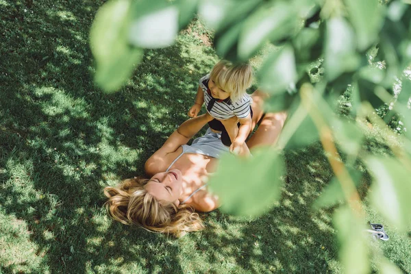 Schattige Blonde Jongen Spelen Met Jonge Moeder Groen Gras Buiten — Stockfoto