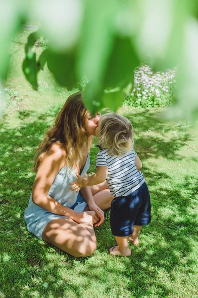 Ung Mamma Kysser Söt Blond Pojke Grönt Gräs Utomhus Sommaren — Stockfoto