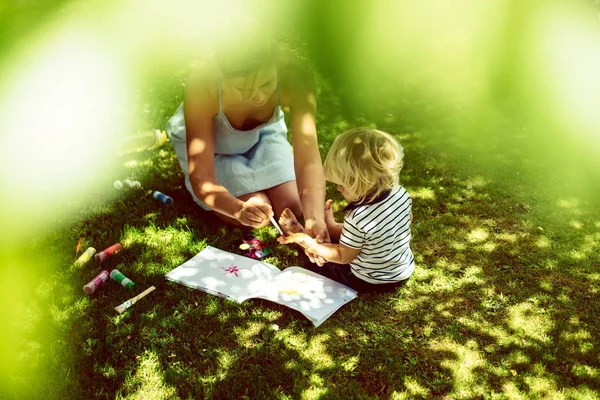 Cute Blonde Boy Drawing Young Mother Green Grass Outdoor — Stock Photo, Image