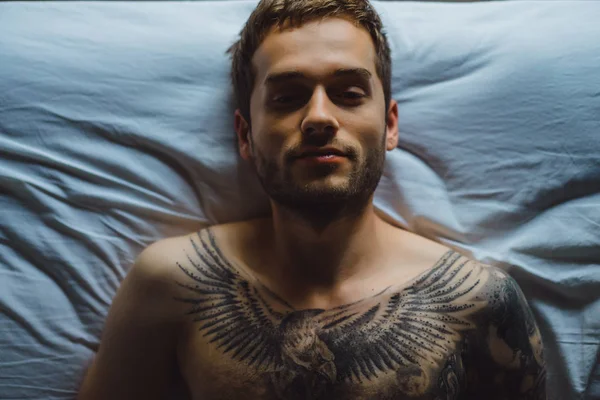 Yatakta dövmeli adam 