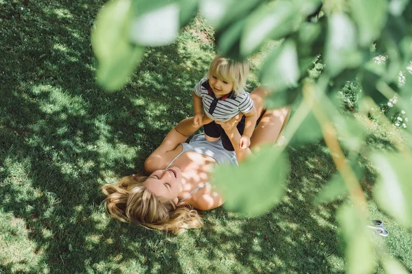 Schattige Blonde Jongen Spelen Met Jonge Moeder Groen Gras Buiten — Stockfoto