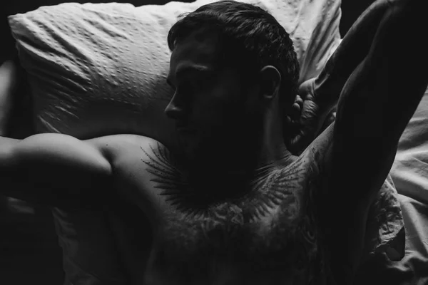 Tattooed man in bed — Stockfoto