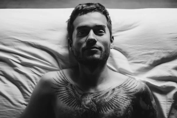 침대에서 문신된 남자 — 스톡 사진