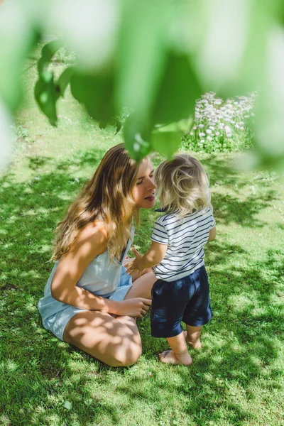 Young Mother Kissing Cute Blonde Boy Green Grass Outdoor Summer — Stock Photo, Image