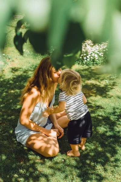 Jovem Mãe Beijando Bonito Loira Menino Grama Verde Livre Verão — Fotografia de Stock