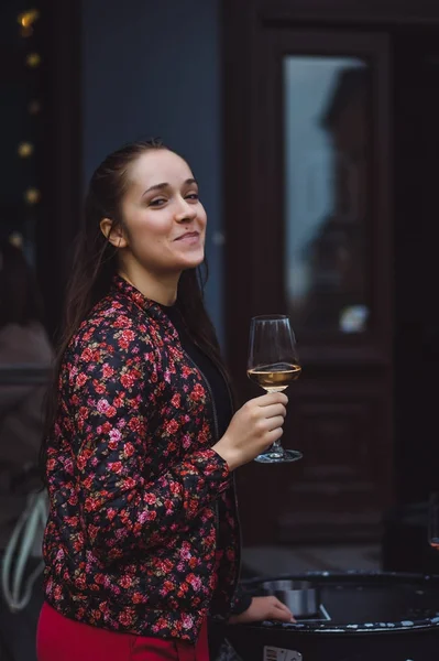 şarap bardağını tutan ve gülümseyen kadın