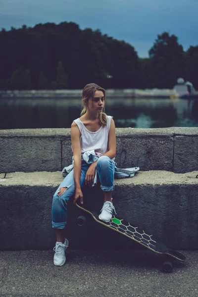 Quay longboard ile oturan kız