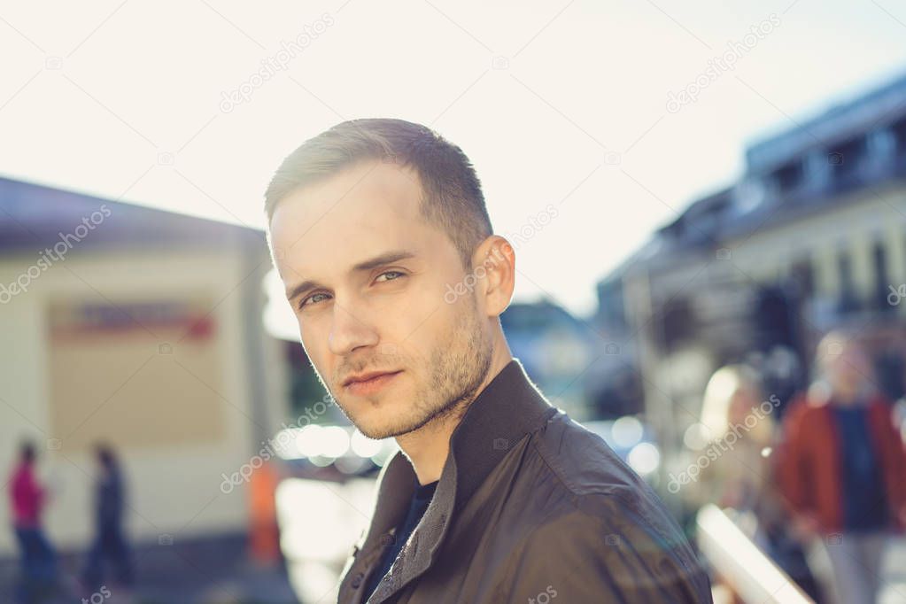 Young man on street looking at camera