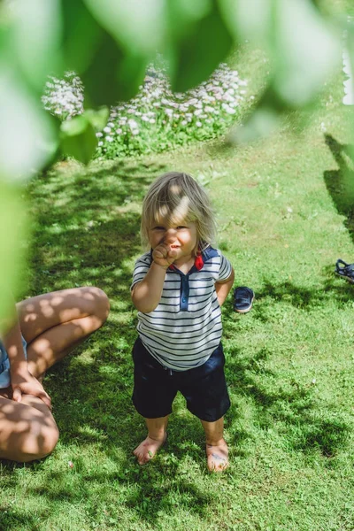 sevimli sarışın çocuk üzerinde yeşil çim açık genç anne ile