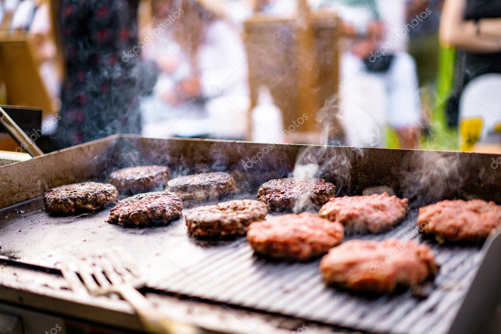 The grilling process of preparing meat cutlets for burgers. Cheeseburger cutlet