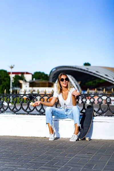 Schöne Und Sexy Mädchen Sitzt Auf Einem Skateboard Und Isst — Stockfoto