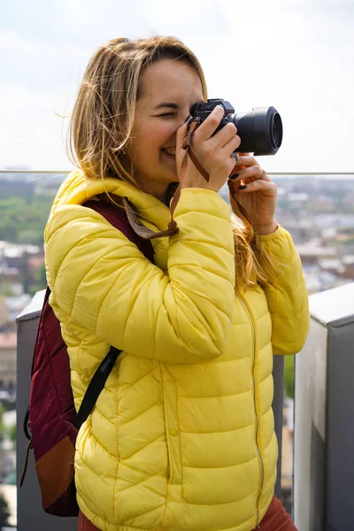 旅行中的女人从高处拍摄城市的照片 女的带着相机 女摄影师 — 图库照片