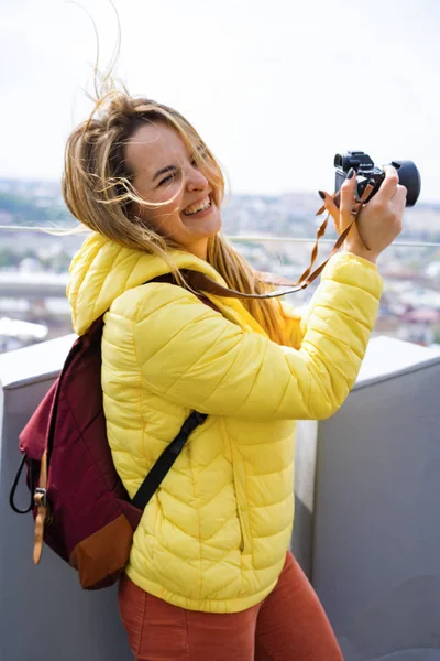 woman on a trip takes photos of the city from a height. Female with a camera. Women photographer