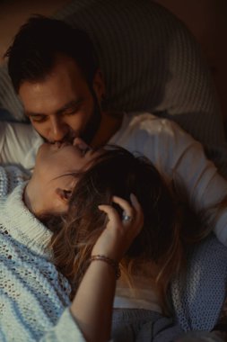 Genç aşıklar evlerinde kanepede kedileriyle rahat bir akşam geçirirler..