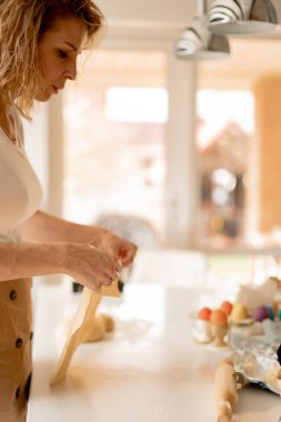 Genç bayan Paskalya pastasını kurutulmuş meyve ve kuru üzümle hazırlıyor.