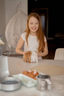 Çocuklar paskalya tavşanlarıyla oynarlar.