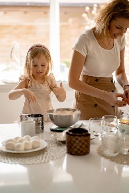 Kız anneme mutfakta Paskalya pastası pişirmesinde yardım ediyor. Mutlu aile Paskalya için hazırlanıyor.