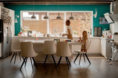 Anne ve kızları yumurta boyuyor. Mutlu aile Paskalya için hazırlanıyor..