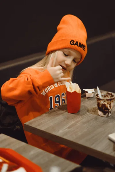 Crianças no McDonald 's. Menina come batatas fritas e bebidas — Fotografia de Stock