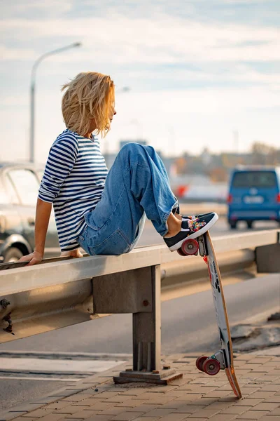 スケートボードで歩く都会的なスタイリッシュな若い女の子。屋外ポーター — ストック写真