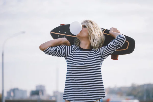 Urban stylish young girl walking with skateboard. Outdoors portr — 스톡 사진