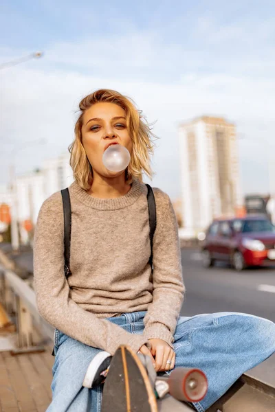 Urban stijlvolle jonge meisje wandelen met skateboard. Buitenportaal — Stockfoto