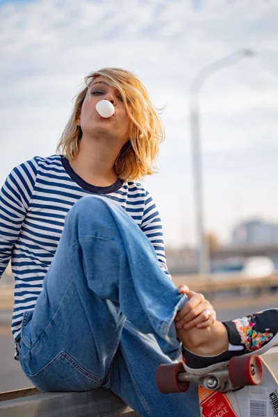 Chica joven con estilo urbano caminando con monopatín. Portero exterior — Foto de Stock