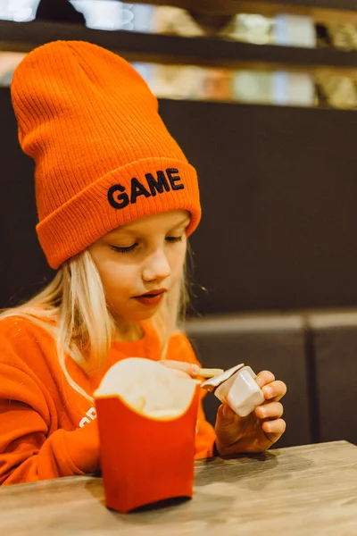 Children at mcdonald's. Little girl eats french fries and drinks — Stock Photo, Image