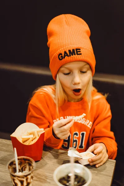 Children at mcdonald's. Little girl eats french fries and drinks — Stock Photo, Image