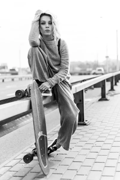 Городская стильная молодая девушка, гуляющая со скейтбордом. Внешний вестибюль — стоковое фото
