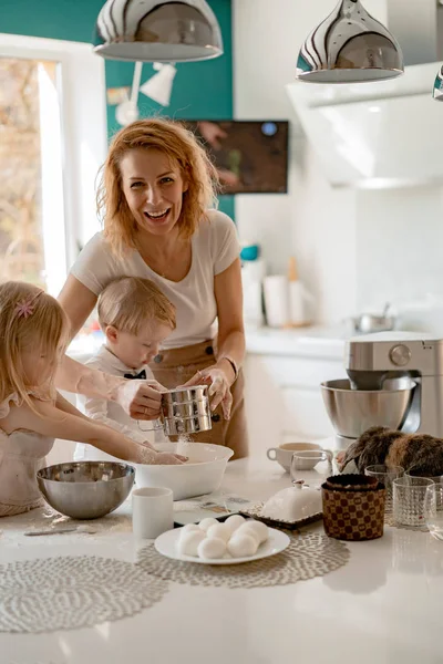 イースター休暇の準備をしている幸せな家族台所の子供とお母さんはケーキを焼くと卵をペイントします 国産ウサギ — ストック写真