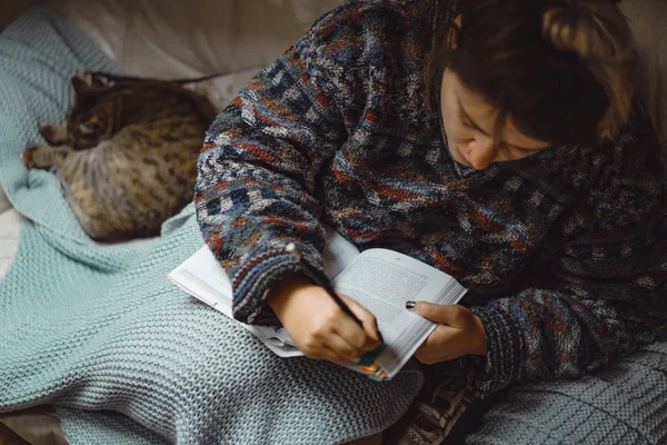 Młoda Kobieta Pod Kratą Kotem Spędza Miło Czas Czytając Ciekawą — Zdjęcie stockowe