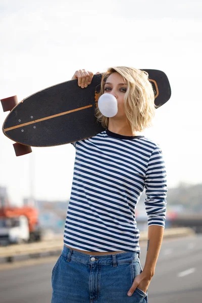 Chica joven con estilo urbano caminando con monopatín. Portero exterior — Foto de Stock