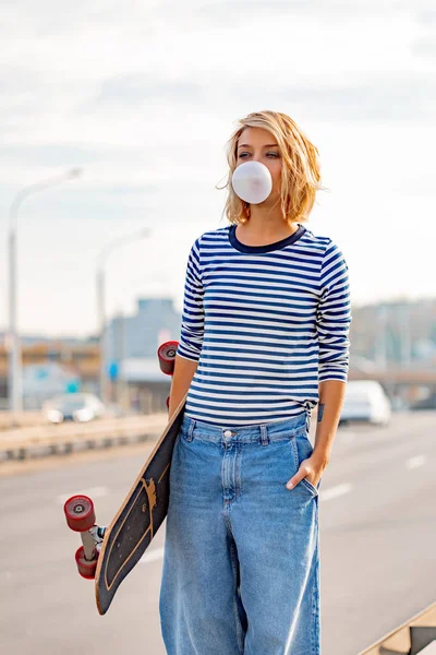 Urban stylish young girl walking with skateboard. Outdoors portr — Stock Photo, Image