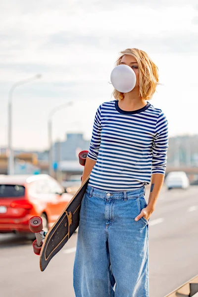 Menina elegante urbana andando com skate. Portador ao ar livre — Fotografia de Stock