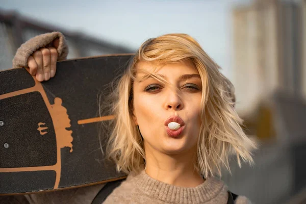 スケートボードで歩く都会的なスタイリッシュな若い女の子。屋外ポーター — ストック写真