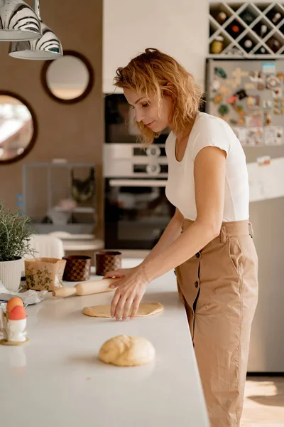 young woman prepares Easter cake with dried fruits and raisins