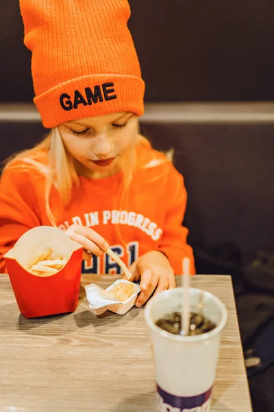 Children at mcdonald's. Little girl eats french fries and drinks — Stock Photo, Image