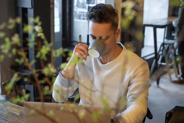 Young Man Drinks Tea Works Laptop Freelancer Working Cafe — Stock Photo, Image