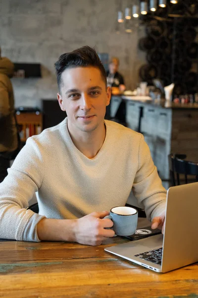 Genç Adam Çay Içiyor Dizüstü Bilgisayarda Çalışıyor Kafede Çalışıyor — Stok fotoğraf