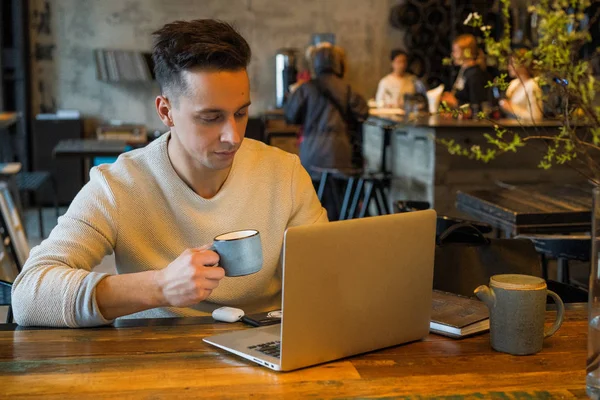 Young Man Drinks Tea Works Laptop Freelancer Working Cafe — Stock Photo, Image