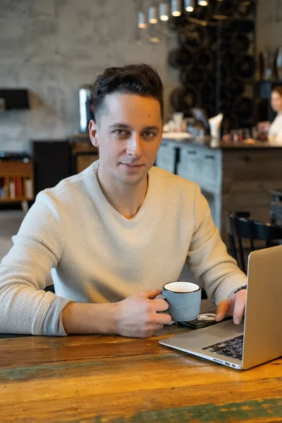 Young Man Drinks Tea Works Laptop Freelancer Working Cafe — Stock Photo, Image