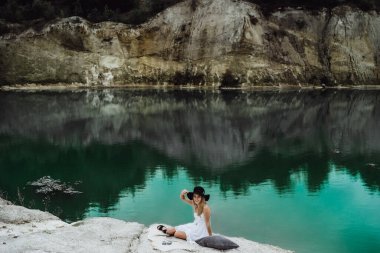 Dünyanın kıyısındaki doğada yaşayan genç bir kadın. Göl, dağlar.