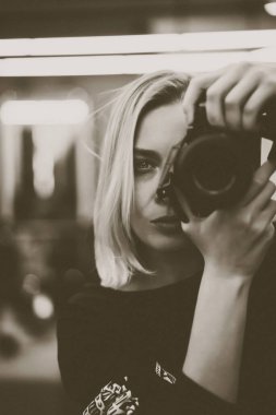 Fotoğraf makinesi olan genç bir kadın.