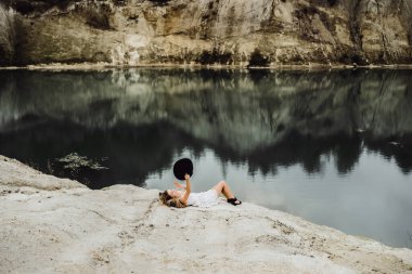 Dünyanın kıyısındaki doğada yaşayan genç bir kadın. Göl, dağlar.